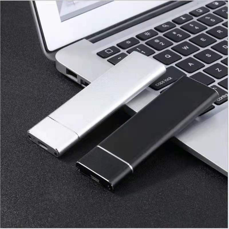 Deux disques SSD portables, un argenté et un noir, posés sur un clavier d'ordinateur portable. Accessoires de stockage externe haute vitesse.