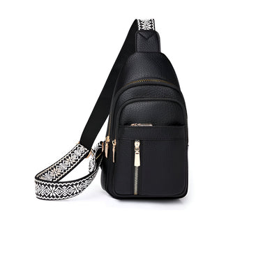 Sac à bandoulière noir en cuir avec fermeture éclair dorée et sangle à motif géométrique blanc et noir, idéal pour un style urbain et moderne.