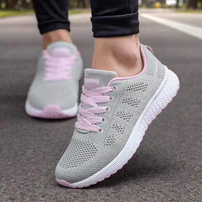 Chaussures de course grises et roses pour femmes sur route, semelle antidérapante, design respirant, idéales pour jogging et fitness.