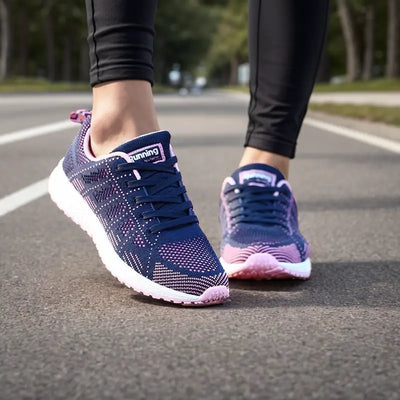 Chaussures de course violettes et roses sur route, portées par une personne en leggings noirs. Idéales pour le jogging et le fitness en extérieur.