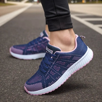 Chaussures de course bleues et roses pour femme sur route, design moderne et confortable, idéales pour le sport et la marche.