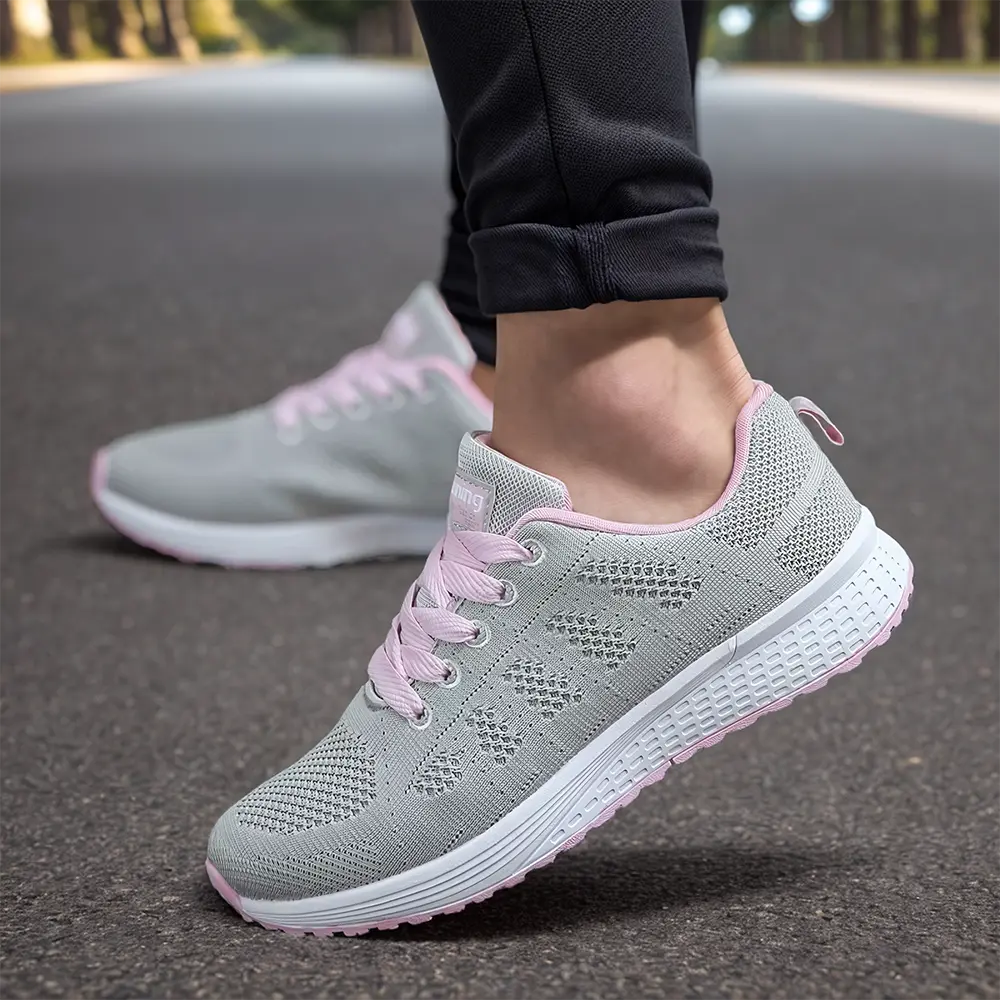 Chaussures de course grises et roses pour femme sur route, confortables et légères, idéales pour jogging et fitness en plein air.