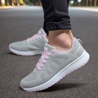 Chaussures de course grises et roses pour femme sur route, confortables et légères, idéales pour jogging et fitness en plein air.