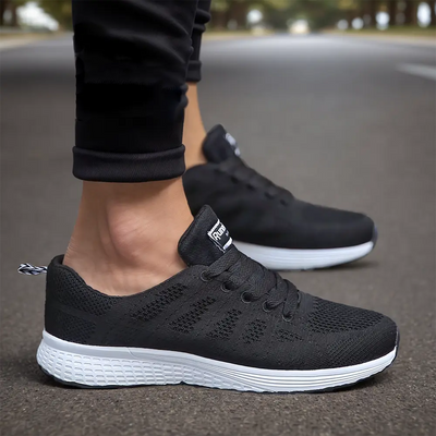 Chaussures de sport noires pour homme sur route, design moderne et confortable, semelle blanche antidérapante, idéales pour course et marche.