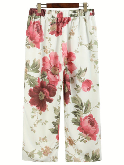 Pantalon ample à motifs floraux rouges et verts sur fond blanc, style décontracté, idéal pour l'été. Mode féminine, tendance et confortable.
