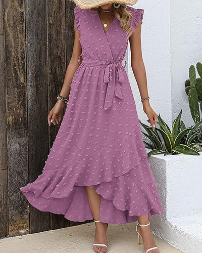 Robe longue violette à volants, ceinture nouée, motif à pois, portée par une femme. Mode estivale élégante, tendance robe d'été féminine.