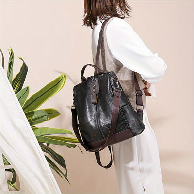 Sac à dos en cuir noir élégant porté par une femme, style moderne et chic, idéal pour le travail ou les voyages. Accessoire mode tendance.
