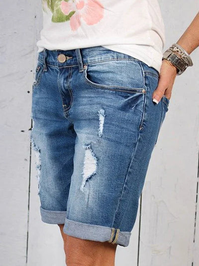 Short en jean déchiré pour femme, style décontracté, avec revers, poches avant, et détails usés. Mode estivale tendance, tenue décontractée.