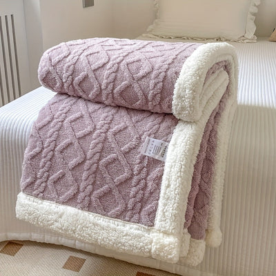 Couverture en laine rose et blanche texturée, posée sur un lit blanc, idéale pour la décoration intérieure et le confort hivernal.