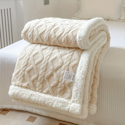 Couverture en laine beige texturée, posée sur un lit blanc, idéale pour la décoration intérieure et le confort. Accessoire maison élégant et douillet.