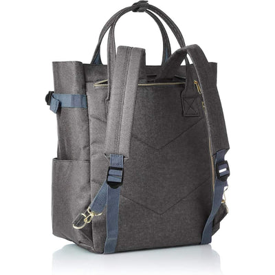 Sac à dos convertible gris en toile avec bretelles réglables, poches latérales et poignées supérieures. Design moderne et fonctionnel.