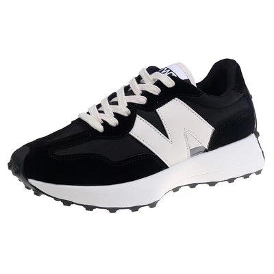 Chaussure de sport noire et blanche avec semelle épaisse, lacets blancs, design moderne. Baskets tendance pour homme et femme, confort et style.