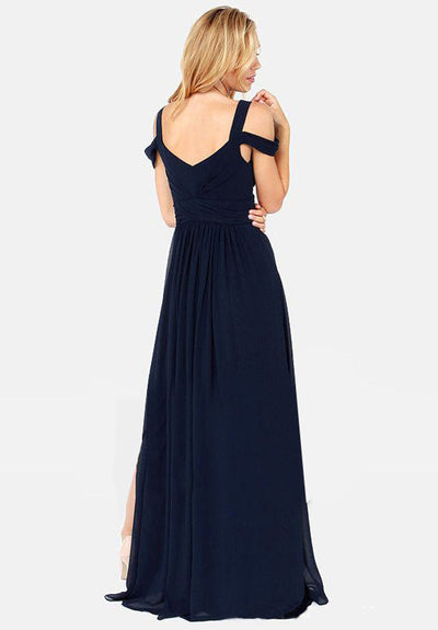 Robe longue élégante bleu marine, dos nu, bretelles croisées, femme blonde, mode soirée, style chic et sophistiqué, fond blanc.