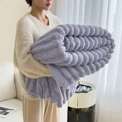Femme tenant une couverture en peluche grise, douce et moelleuse, dans un salon moderne. Tissu confortable, idéal pour la décoration intérieure.
