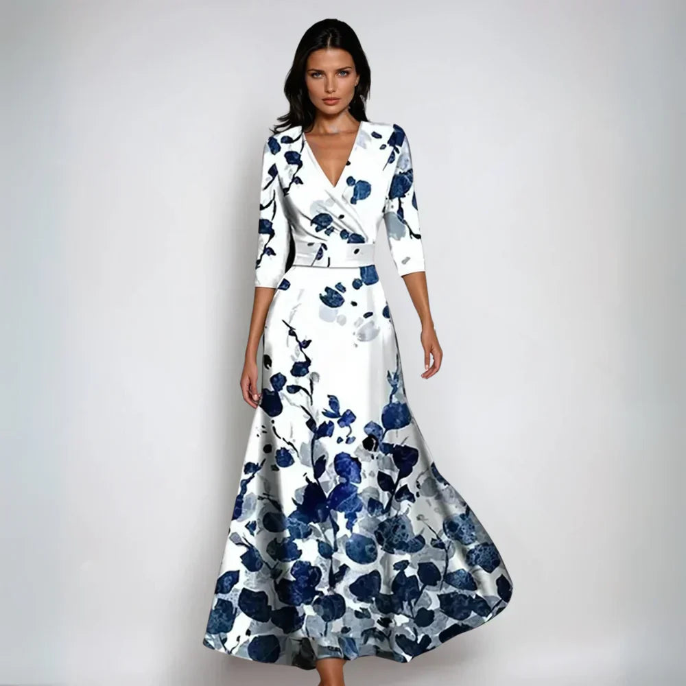 Robe longue élégante à motifs floraux bleus et blancs, manches trois-quarts, style chic et moderne, idéale pour soirées ou événements formels.