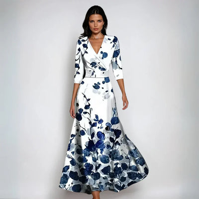 Robe longue élégante à motifs floraux bleus et blancs, manches trois-quarts, style chic et moderne, idéale pour soirées ou événements formels.