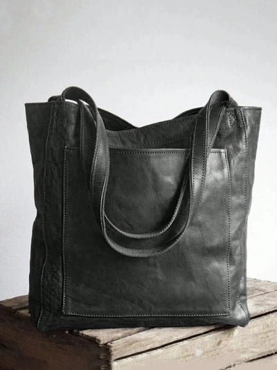 Sac cabas en cuir noir élégant sur fond neutre, design moderne avec anses robustes, parfait pour un usage quotidien et tendance mode.