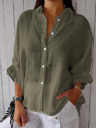Chemise en lin vert olive pour femme, manches retroussées, boutons blancs, portée avec un pantalon blanc. Mode décontractée élégante.