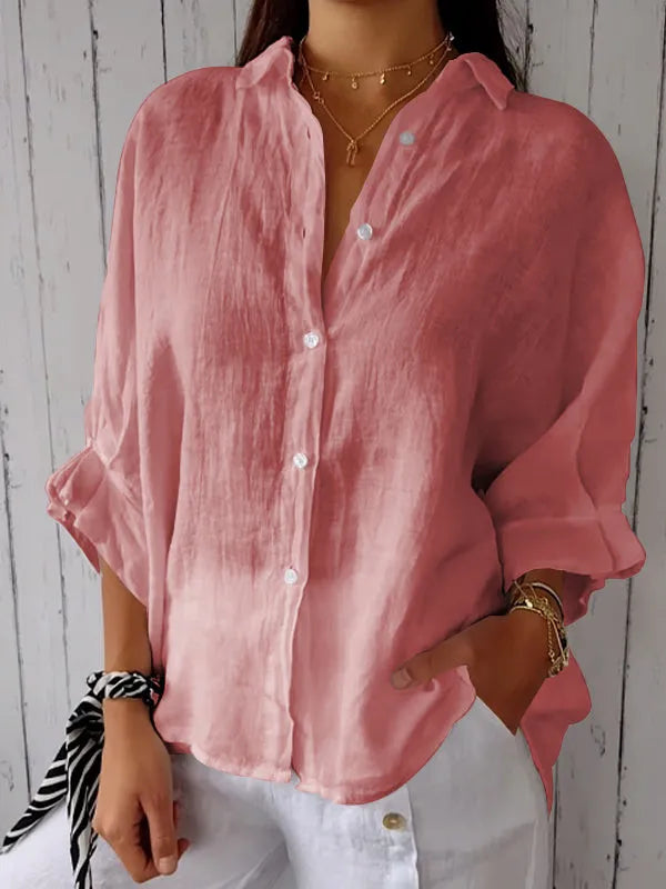 Chemise en lin rose pour femme, manches retroussées, boutons blancs, portée avec un pantalon blanc. Mode décontractée élégante.