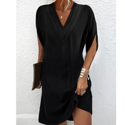 Robe noire élégante à manches courtes, col en V, tenue chic pour femme, accessoirisée avec un bracelet doré et une pochette. Mode féminine tendance.