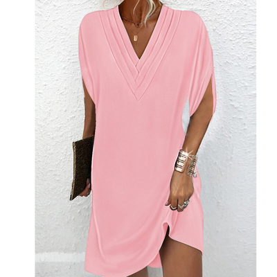 Robe rose élégante à col en V, manches courtes, tenue d'été chic. Accessoires: bracelet doré, pochette noire. Mode féminine tendance.