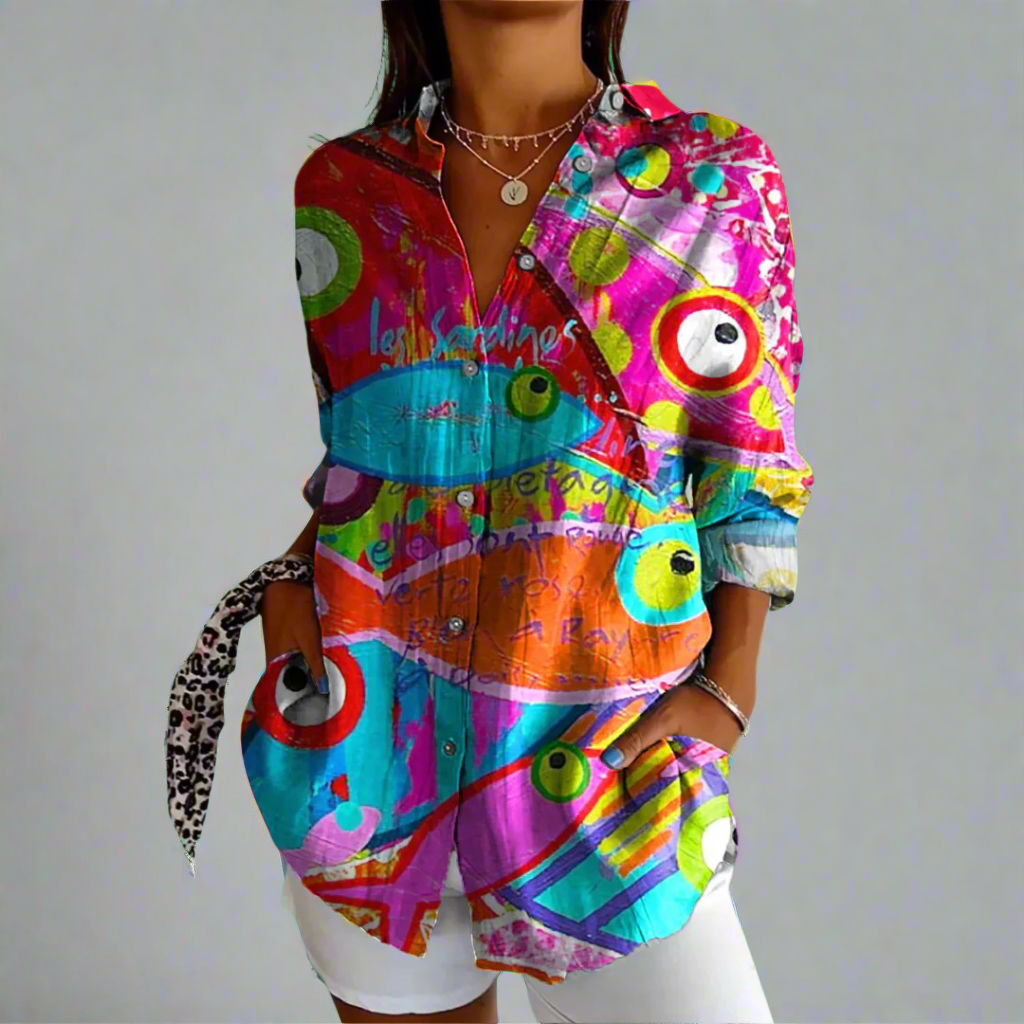 Chemise colorée à motifs abstraits, manches longues, portée par une femme. Style moderne et vibrant, idéal pour la mode urbaine et tendance.