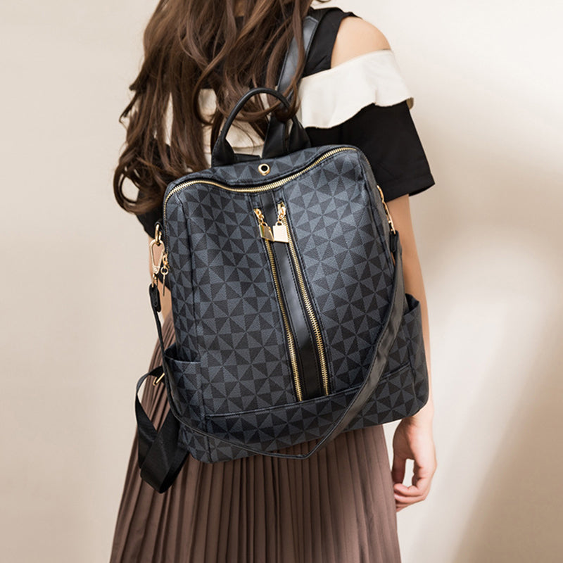 Sac à dos noir élégant avec motif géométrique, porté par une femme. Design moderne, fermeture éclair dorée, idéal pour mode urbaine et voyages.