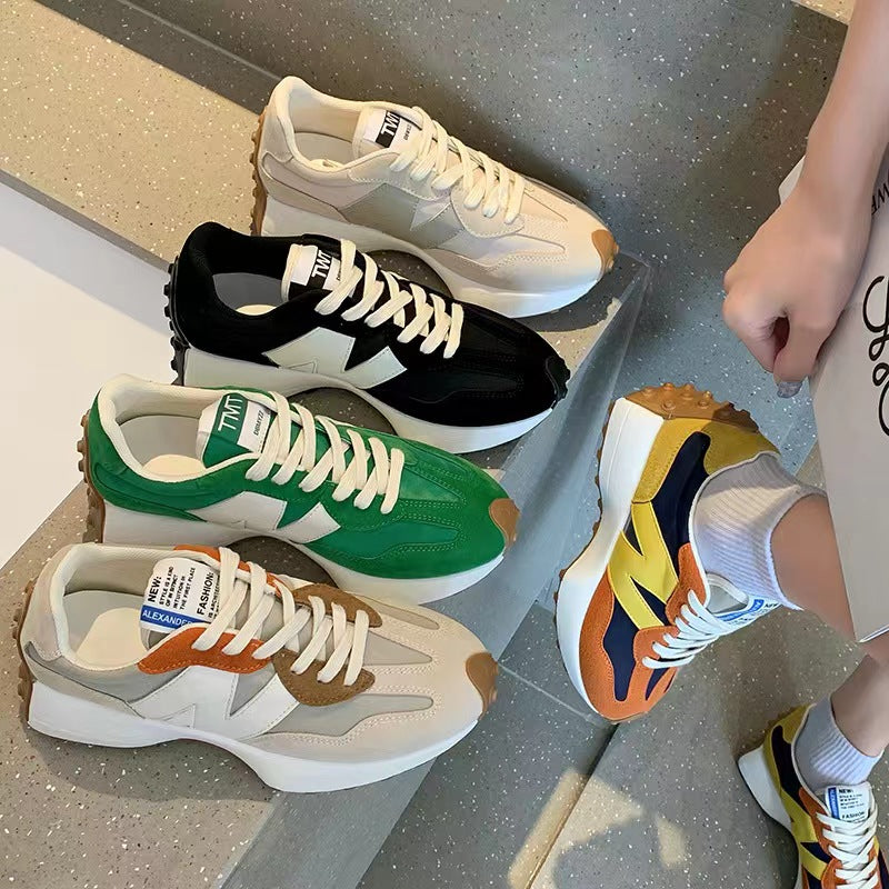 Quatre paires de baskets colorées sur un escalier, avec une main tenant une paire jaune et bleue. Chaussures tendance, mode urbaine, style décontracté.