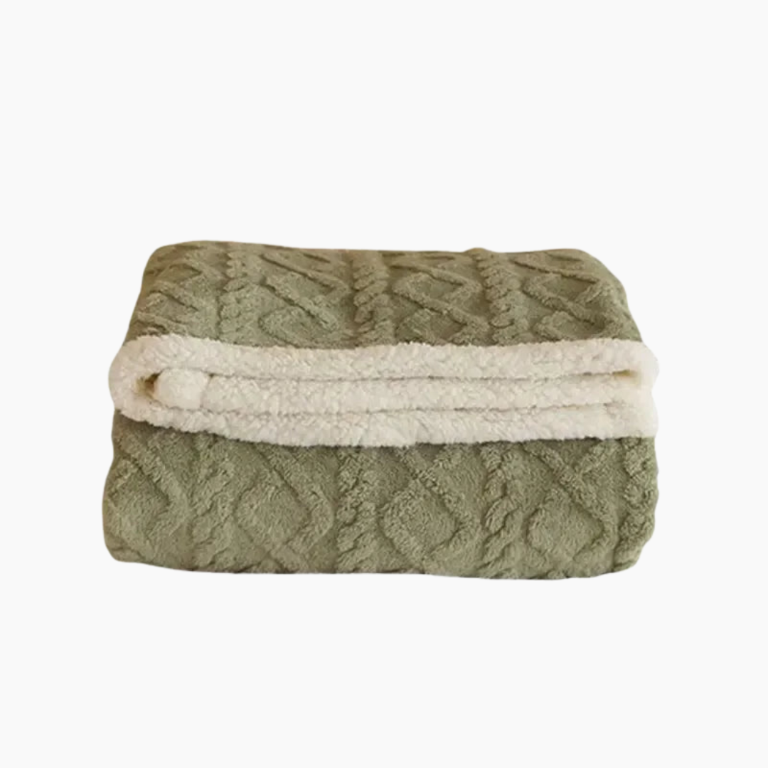 Couverture en laine polaire verte pliée, motif texturé, bordure blanche douce. Idéale pour salon, chambre, confort et décoration intérieure.