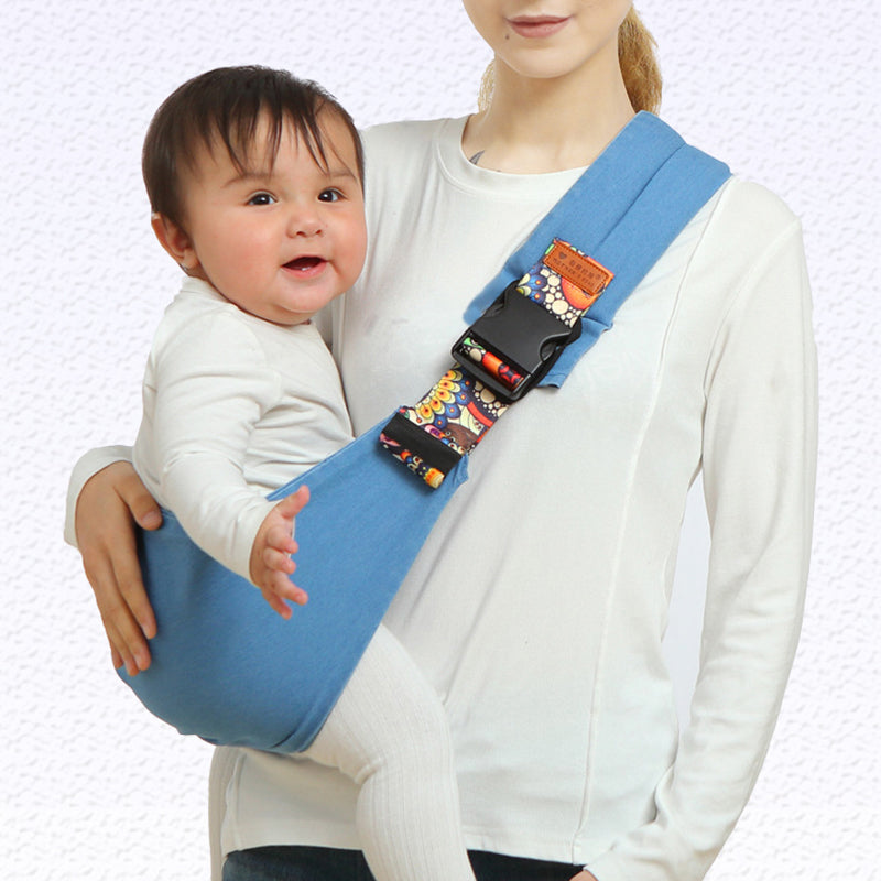 Femme portant un bébé dans un porte-bébé bleu ergonomique. Accessoire parentalité, confort, sécurité, tissu doux. Idéal pour promenade, usage quotidien.