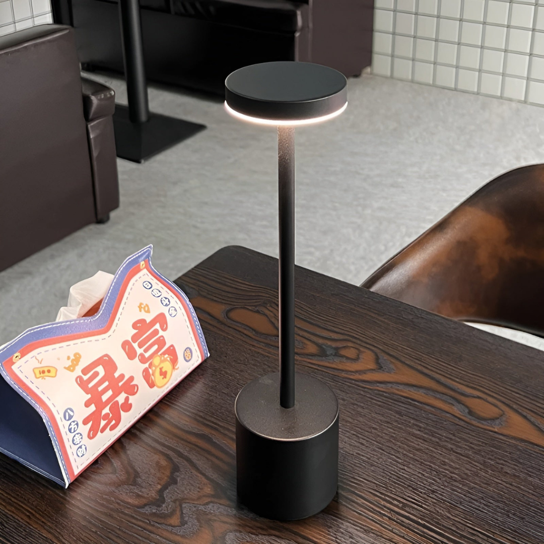 Lampe de table moderne noire sur une table en bois, éclairage LED, design minimaliste. Décor intérieur élégant, ambiance contemporaine.
