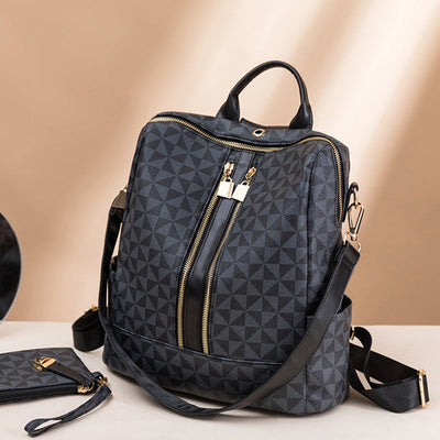 Sac à dos en cuir noir avec motif géométrique, fermetures éclair dorées et bandoulière réglable. Accessoire mode élégant et pratique.