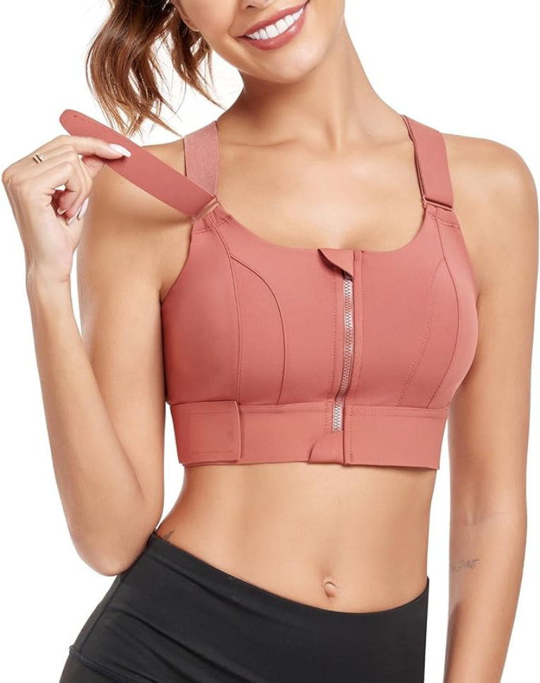 Femme portant un soutien-gorge de sport rose avec fermeture éclair, bretelles ajustables, idéal pour fitness et yoga. Mode active, confort, soutien.