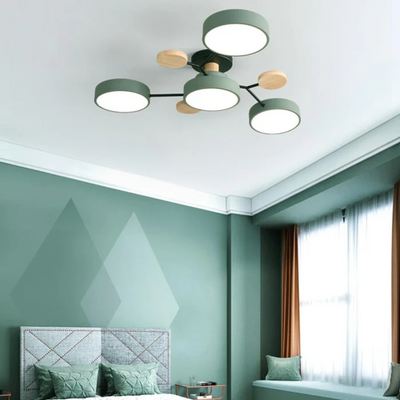Plafonnier moderne à cinq lumières LED dans une chambre verte élégante, avec des accents en bois et un design minimaliste. Éclairage intérieur contemporain.