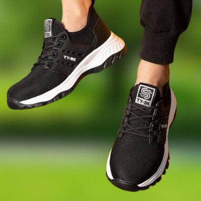 Chaussures de sport noires TY-3K pour homme, semelle blanche, portées en extérieur. Confortables et légères, idéales pour la course et le fitness.