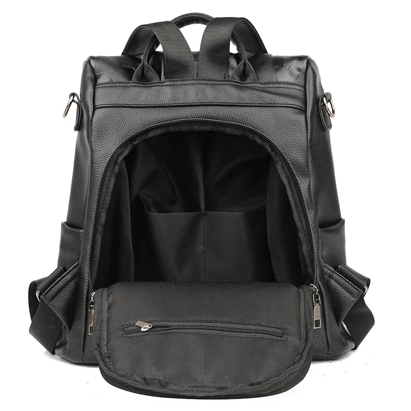 Sac à dos noir en cuir synthétique, ouvert, avec compartiments spacieux. Idéal pour le voyage, l'école ou le travail. Design moderne et fonctionnel.