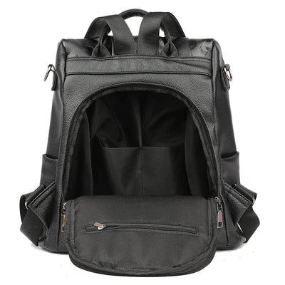Sac à dos noir en cuir synthétique, ouvert, avec compartiments spacieux. Idéal pour le voyage, l'école ou le travail. Design moderne et fonctionnel.