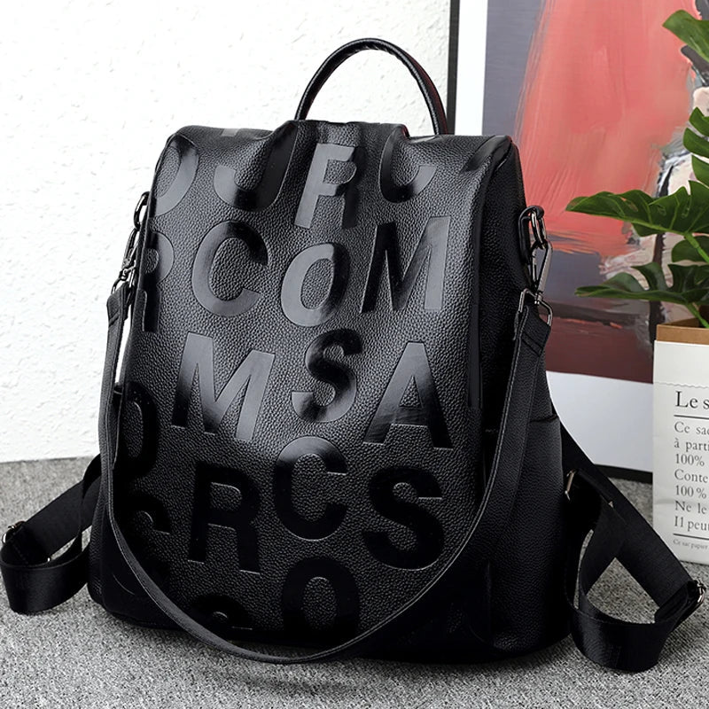 Sac à dos en cuir noir avec lettres en relief, design moderne et élégant, idéal pour la mode urbaine et le quotidien. Accessoire tendance.