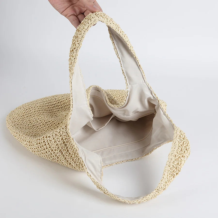 Sac en paille tressée beige avec doublure intérieure blanche, idéal pour l'été. Sac à main tendance, mode éco-responsable, accessoire plage.