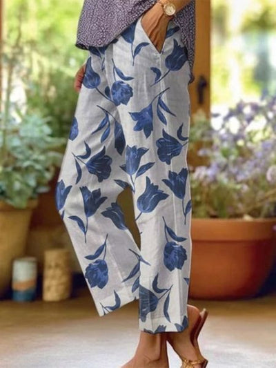 Pantalon femme en lin blanc à motifs floraux bleus, style décontracté, idéal pour l'été. Mode féminine, confort et élégance.