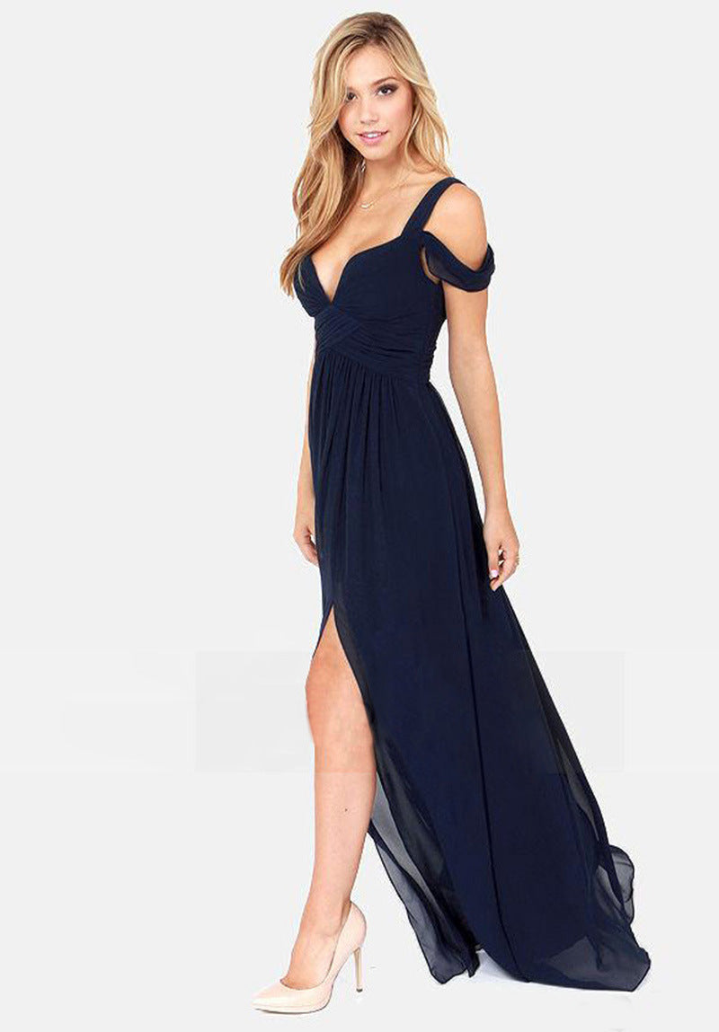 Femme en robe longue bleue élégante avec décolleté en V et fente, posant sur fond blanc. Mode féminine, tenue de soirée chic.