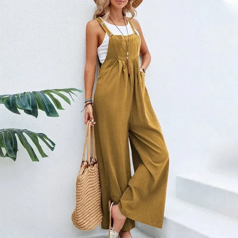 Femme en salopette jaune moutarde, chapeau de paille, sac en osier, posant près d'un mur blanc. Mode estivale décontractée, tendance et élégante.