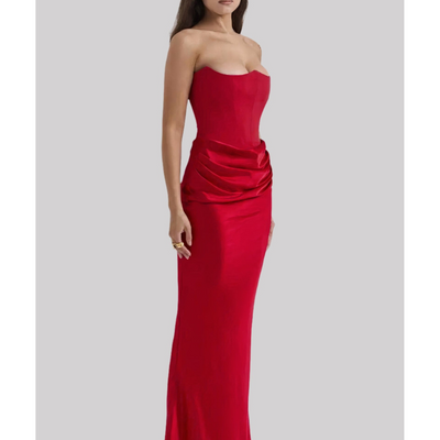 Robe longue rouge élégante sans bretelles, ajustée, avec drapé à la taille, sur fond gris. Mode féminine, tenue de soirée chic.