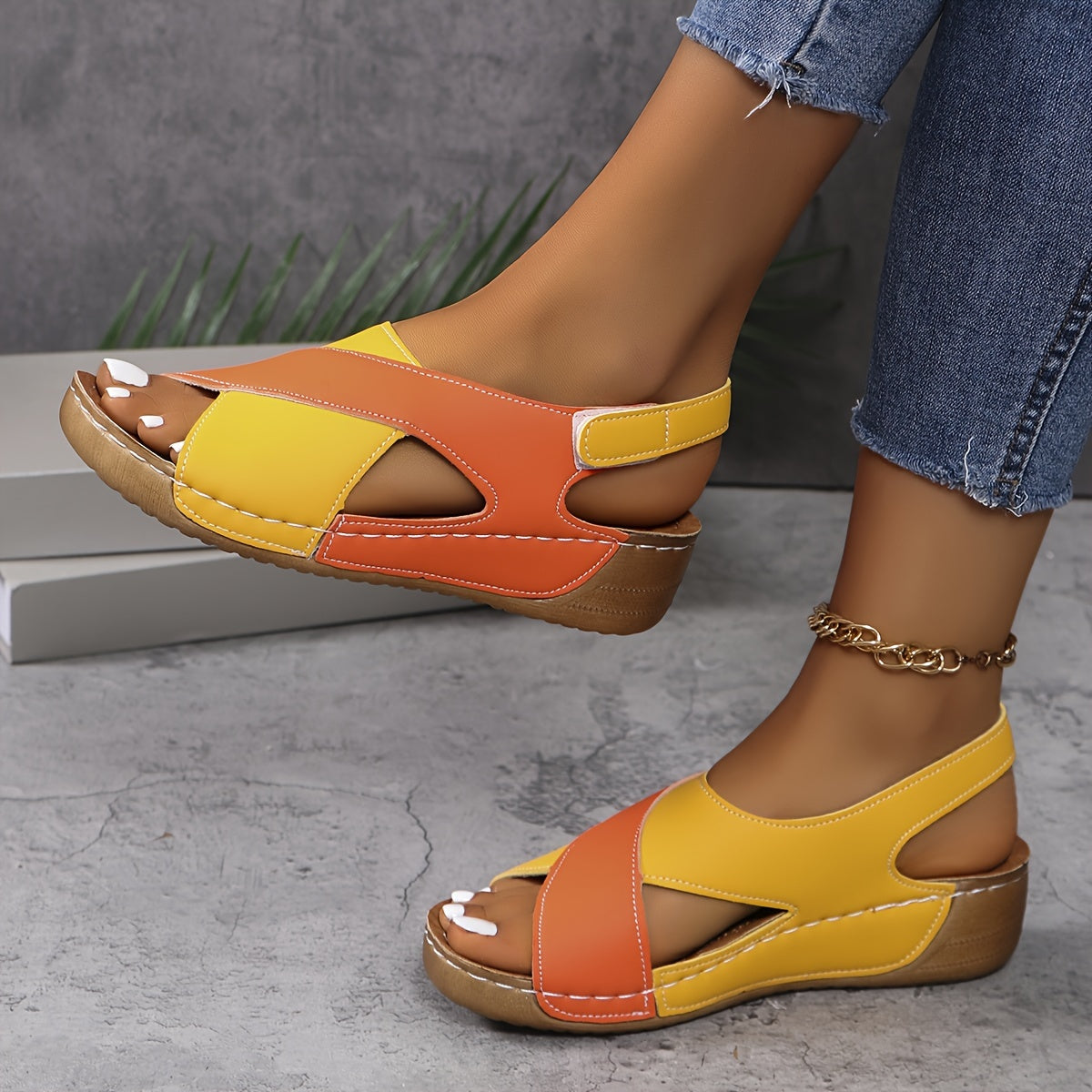 Sandales compensées colorées en cuir jaune et orange, portées avec un jean. Chaussures d'été tendance pour femmes, confortables et élégantes.