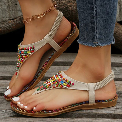 Sandales bohèmes pour femmes avec perles colorées, semelle en corde tressée, portées avec un jean. Mode estivale, chaussures décontractées élégantes.