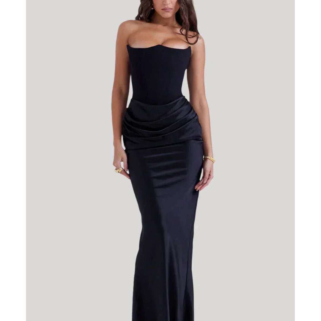 Robe longue noire élégante sans bretelles, ajustée, avec drapé à la taille, portée par une femme. Mode soirée chic, tendance, glamour.