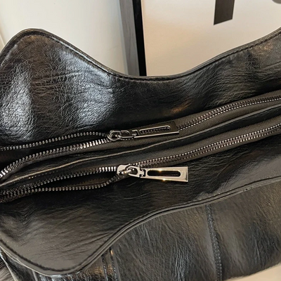 Sac en cuir noir avec fermetures éclair argentées, design élégant et moderne, accessoire de mode tendance pour femmes, style urbain chic.