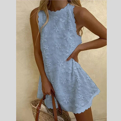 Robe d'été bleue en dentelle florale, sans manches, avec ourlet festonné, portée par une femme tenant un sac en osier. Mode féminine élégante.