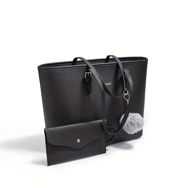 Sac à main noir élégant avec porte-monnaie assorti, pompon décoratif gris, design moderne, accessoires mode femme, cuir synthétique.