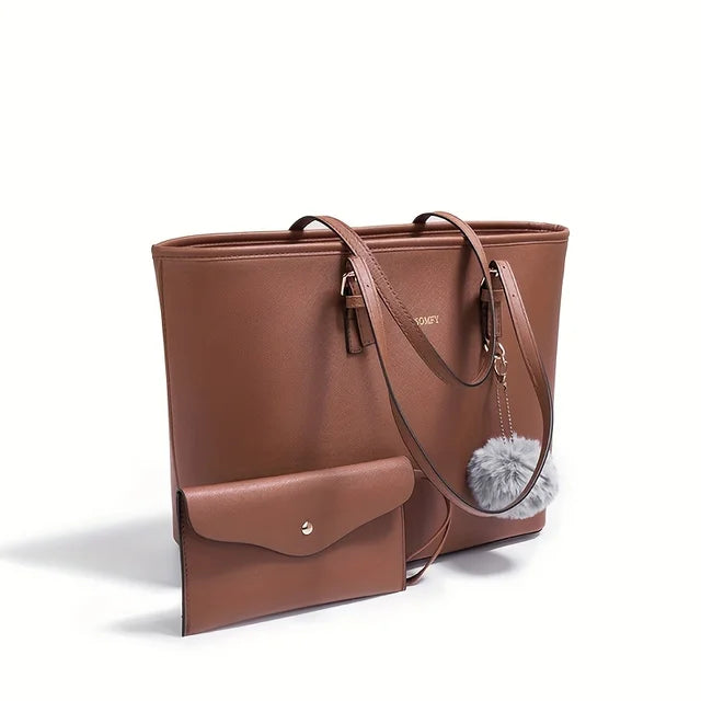 Sac à main en cuir marron avec pochette assortie, pompon décoratif gris, design élégant et moderne, accessoire mode femme tendance.